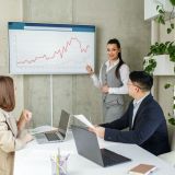 businesswoman-leads-presentation-with-colleagues-uses-presentation-tv-with-charts-e1701874981211.jpg